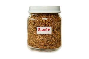 Cumin in a glass jar isolated on a white background. photo