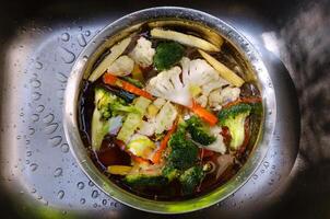 Vegetables at kitchen sink, washing fresh vegetables water with colorful fresh vegetables in the background, emphasizing healthy eating photo
