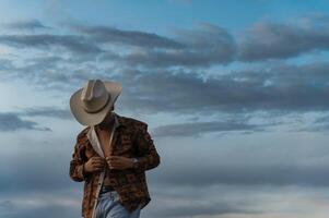 Mexican Cowboy preparing for a day of work against a cloudy sky in the countryside photo
