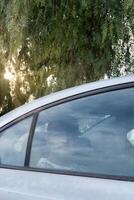 Person in a car looking out the window during a sunny afternoon photo
