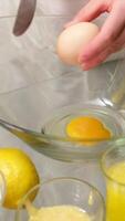 chef cracking egg with knife and separating yolks from whites, putting egg whites into bowl and egg yolks into glass video