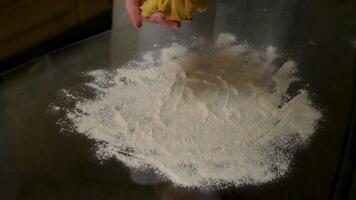 Hands kneading dough on a countertop with scattered flour and ingredients. video