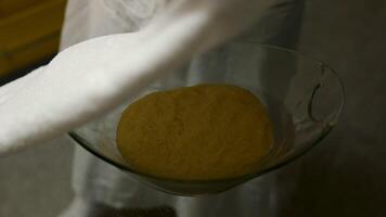 Close-up of dough lying on table and sprinkled with flour, covered with a towel by female hands. video
