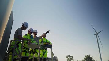 Team of technicians through a wind farm, showcasing teamwork and safety practices in renewable energy work video