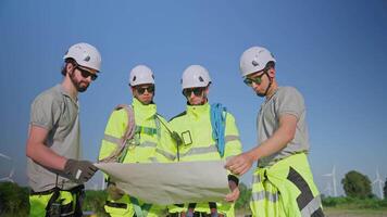 Team of technicians walking through a wind farm showcasing teamwork and safety practices in renewable energy work video