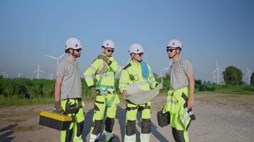 Team of technicians walking through a wind farm, showcasing teamwork and safety practices in renewable energy video