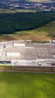 Aerial view of a factory or industrial area surrounded by green fields. Modern industrial factory Vertical video