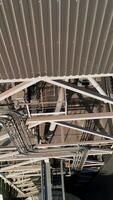 Modern metal grain elevator on field. Granary for storing and processing agricultural crop. Aerial view. Vertical video