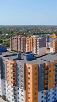 New residential complex with high-rise buildings. Modern multi-storey buildings with colorful walls. Construction site of new residential area at sunlight. Vertical video