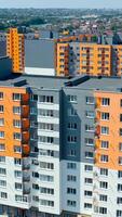 Facade of a modern apartment building. Colorful walls of a new multi-storey building with balconies and windows. High residential building in sunny day. Vertical video