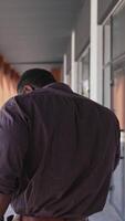 African american man talking the phone outdoors. Back view of unrecognizable man solving business problems through the phone in the city. Rear view. Vertical video
