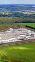 Aerial view of modern industrial building surrounded by green fields. video