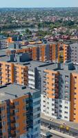 Residential complex with multi-storey buildings. Modern area with new skyscrapers in the outskirts of a city. Colorful architecture of urban housing. Aerial view. Vertical video