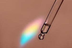 Pipette with cosmetic product with iridescent highlights in mocha mousse color photo