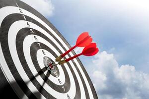 target with two red dart on blue sky background photo