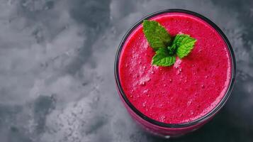 Delicious and creamy blackberry smoothie garnished with fresh mint leaves, offering a refreshing and gray background healthy eating preparation for menu, recipe and food blog copy space photo