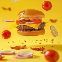 .Delicious burger with bacon on yellow background with levitating vegetables and ingredients. Advertising poster with studio light. photo