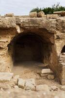 Photo of an ancient tomb in the city of Paphos on a sunny day.
