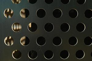 Abstract shiny metal background in silver color with round holes texture. Perforated metal background photo