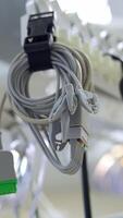 White wires from equipment hanging near the stethoscope in operational theatre. Low angle view. Blurred backdrop. Vertical video