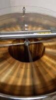 Electric device rotating frames with honey. Machine with opened lid working in the apiary. View from top. Vertical video
