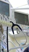 Equipment, wires, devices and instruments in modern surgical room. Low angle view. Medics working at backdrop. Vertical video