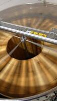 Honey extraction in the electric machine working in the apiary. Apparatus rotating frames to gather honey harvest. Top view. Vertical video