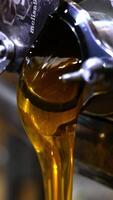 Opened mouth of a honey extracting machine with liquid product flowing from it. Freshly extracted organic food close up. Vertical video