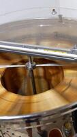 Metal barrel machine for honey extraction. Electric centrifuge spinning and rotating frames inside. View from top. Vertical video