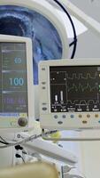Pair of monitors displaying the condition of a patient at operation. Medical respiratory and life support systems in a hospital clinic. Vertical video