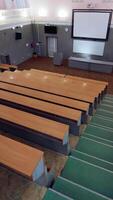 Modern hall for meetings. Large university auditorium with row of desks and a large white board. Empty classroom. Vertical video