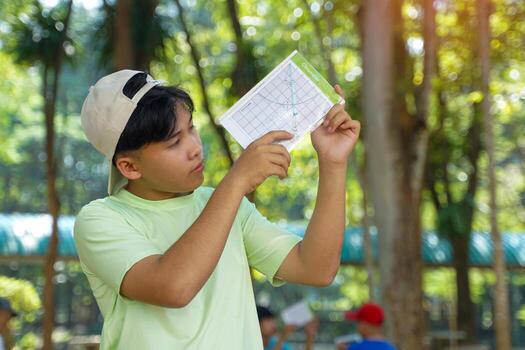 The boys used a clinometer to measure angles to calculate the height of the trees and calculate the trees' carbon storage. photo