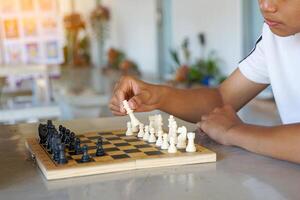 Close-up a hand of a chess player to moving pieces on the board as planned to defeat the opponent. Soft and selective focus. photo