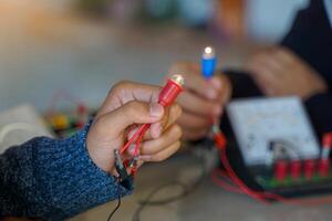 brightness of the light bulb when connected to an electrical circuit in series and a set of equipment connected to the electrical circuit, including a voltmeter, ammeter, wires and electrical bridge. photo