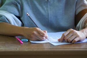 students are taking exams to measure learning in the classroom. Soft and selective focus. photo