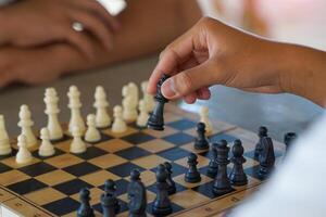 Close-up of chess player's hand moving pieces on the board as planned to defeat the opponent. Soft and selective focus. photo