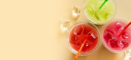 Banner with colours summer drinks with ice on beige background. photo