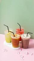 Colourful summer drinks with ice. Lemonade on colored background photo