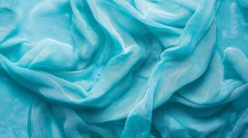 Turquoise fabric soaked in water with ripples and waves. Abstract background for fabric and design presentations photo