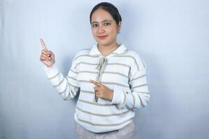 Beautiful asian woman pointing her finger to empty copy space isolated on white background photo