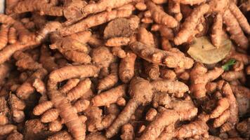 Close up of fresh turmeric roots in the wicker basket at Indonesia traditional market photo