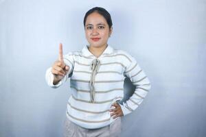 Beautiful asian young woman wearing sweater showing fingers number one while smiling confident photo