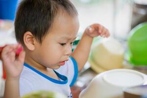 Close-up portrait of a young boy's face showing a look of curiosity and surprise at something he sees in front of him. Two-year-old Asian boy. photo