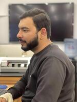 Portrait of a young man working diligently at his desk in an office environment, with a focused and professional expression photo