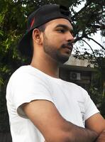 Portrait of a young man wearing a casual baseball cap and t-shirt, smiling and looking confidently at the camera photo