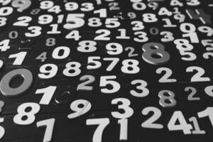 Numbers on a dark wooden background. Black and white. Close-up. photo