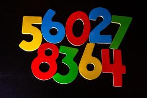 Colorful plastic numbers on blackboard background. Close-up. photo