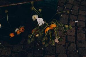 Wilted flowers on sale in a bucket at a market, offering a nostalgic, rustic charm photo
