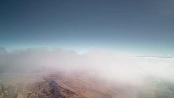 Top view of cloudscape shot during daytime, first person view. Very high altitude flight perspective with curved horizon. 4K video