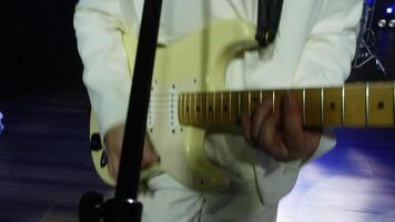 chanteur en jouant guitare tandis que en chantant avec bande dans événement. le batteur en jouant la musique sur batterie dans Contexte. les musiciens sont performant sur illuminé étape à nuit. video